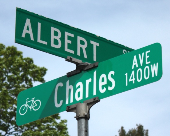The Charles Avenue sign features a bike, a nod to its designation as a bike boulevard. Notice the upper and lower case letters on the Charles Avenue sign and the much more common all upper case on the Albert Street sign.