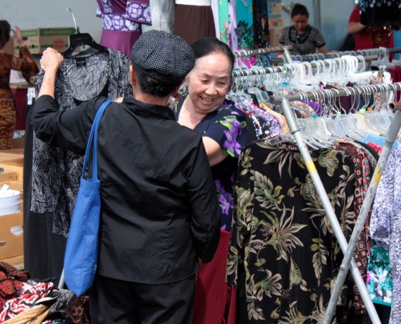 Two women discuss the purchase of a dress at Hmongtown Marketplace.