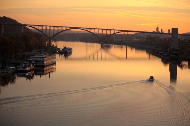 The fading sunlight lends an orange tint to the Mississippi River and the Minnesota Centennial Showboat, left. The Smith Avenue High Bridge is in the middle of the picture.