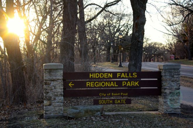 The sun hovers above the horizon as viewed from the Hidden Falls Park entrance.