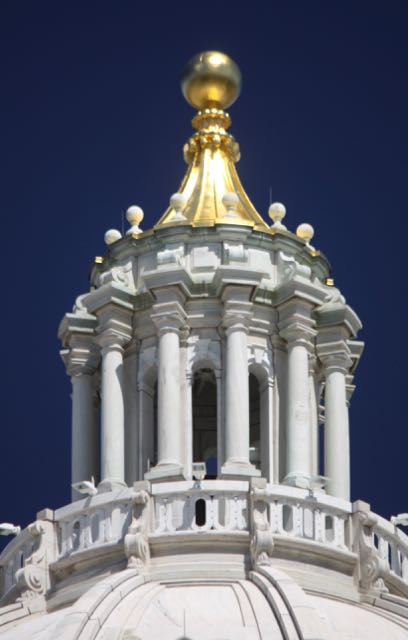 The peak of the Capitol dome glistens in the summer sun.