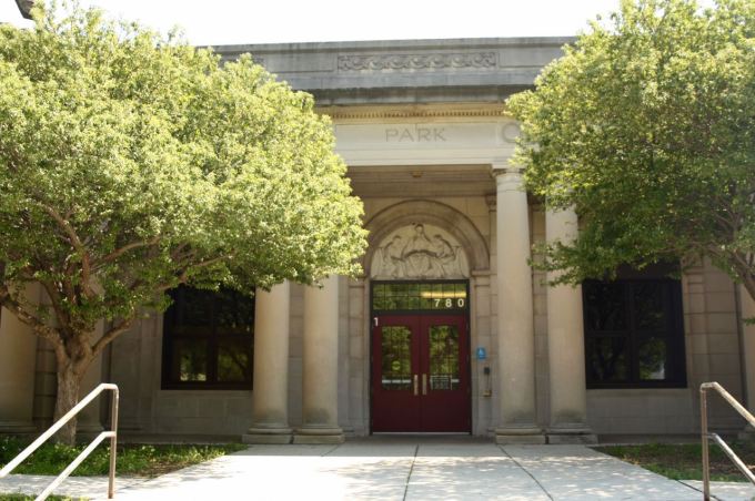 The original main entrance with its prominent frieze above it faces Wheelock Parkway.)