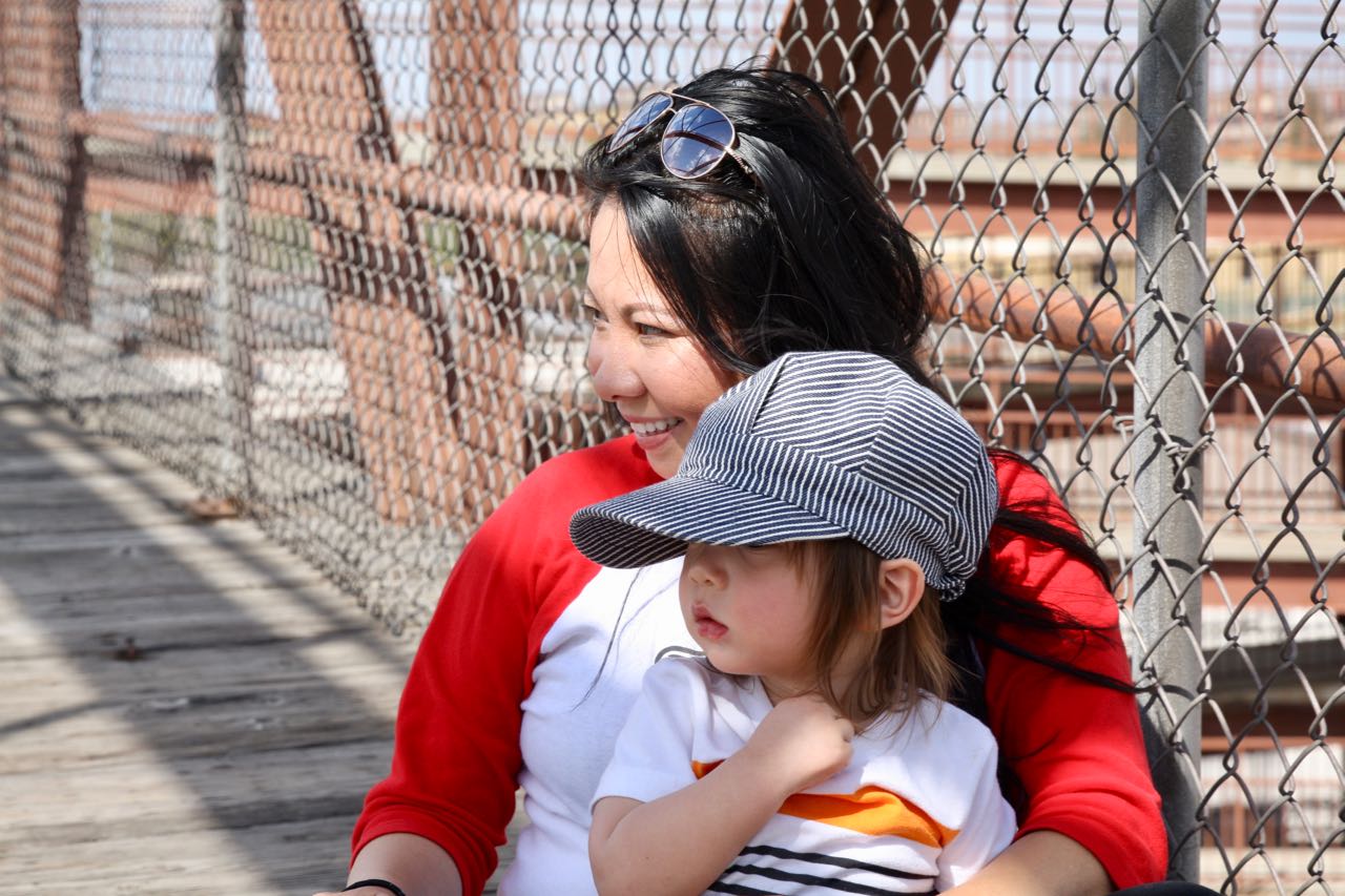 Martha Campo and her son, Owen, watch a nearby train from high above on the Hamline Pedestrian Bridge.