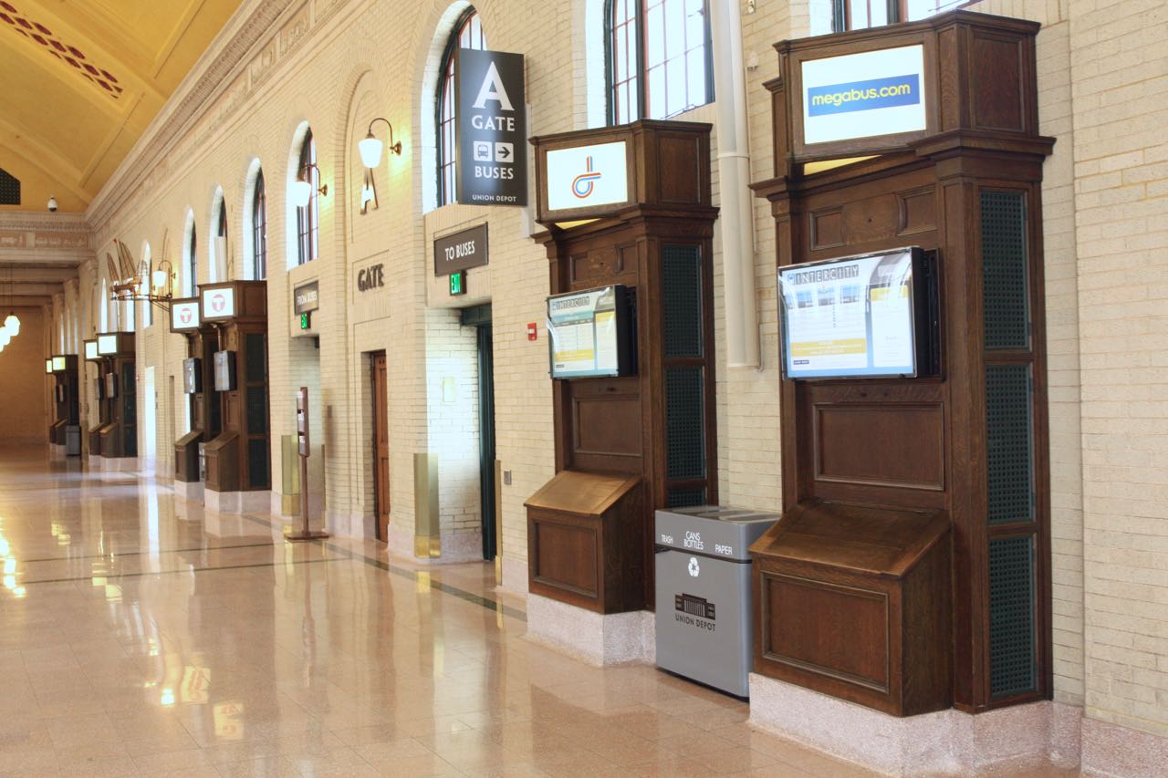 In earlier days, the wood cases on the right were used to display the train schedules for the 21 passenger tracks that served Union Depot. Today, digital screens provide schedules for the bus lines service the Depot.